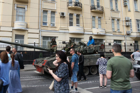Civiles de la ciudad rusa de Rostov pasan delante de un tanque con miembros del grupo Wagner